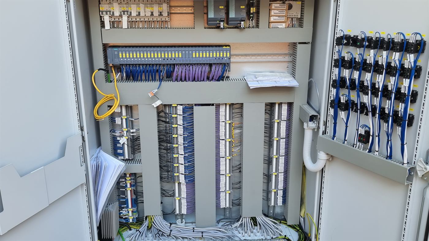 Armario de PLC abierto con módulos de control y cableado de bornas